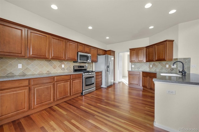 kitchen with decorative backsplash, sink, dark hardwood / wood-style floors, and appliances with stainless steel finishes