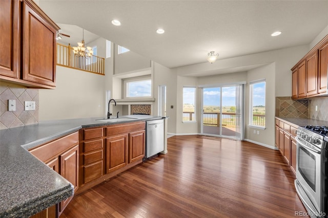 kitchen featuring a wealth of natural light, sink, dark hardwood / wood-style floors, a notable chandelier, and appliances with stainless steel finishes