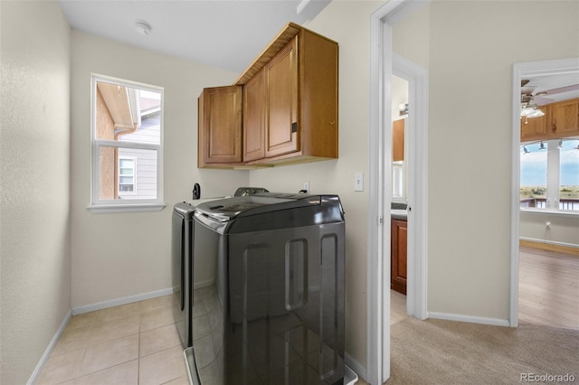 laundry room featuring washer and dryer, ceiling fan, cabinets, and light tile patterned floors