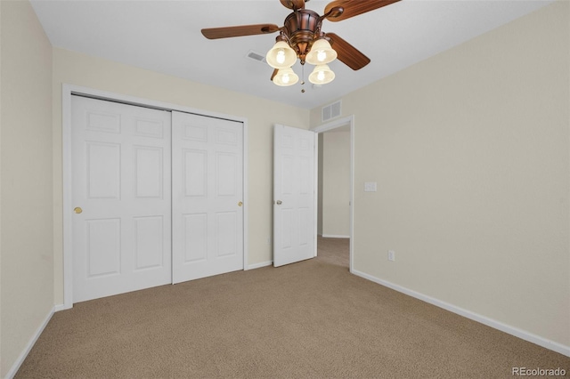 unfurnished bedroom with carpet, a closet, and ceiling fan