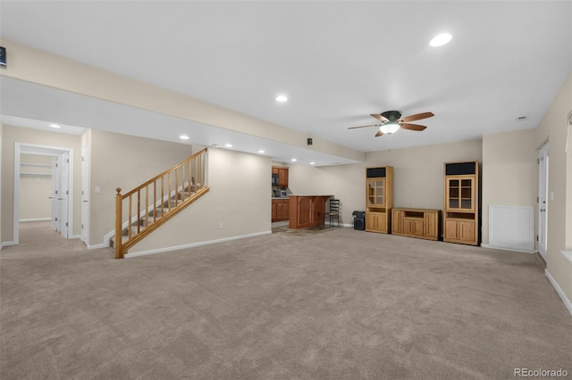 unfurnished living room featuring ceiling fan and light carpet