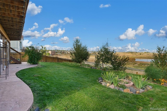 view of yard featuring a water view and a patio