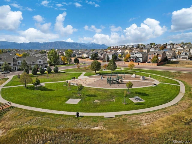 surrounding community with a mountain view and a yard