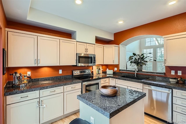 8300 Fairmount Dr Unit Aa102, Denver, CO 80247 - kitchen with appliances with stainless steel finishes, a sink, light wood-type flooring, recessed lighting, and dark countertops