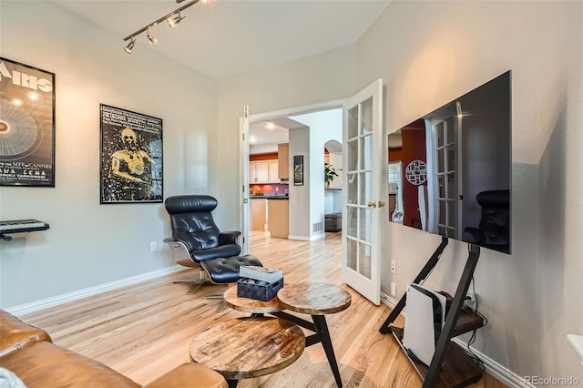 8300 Fairmount Dr Unit Aa102, Denver, CO 80247 - sitting room with french doors, wood finished floors, baseboards, and rail lighting