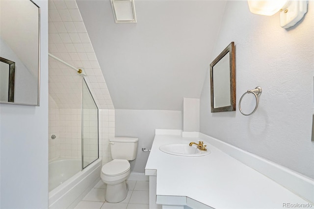 full bathroom with lofted ceiling, toilet, tiled shower / bath, vanity, and tile patterned flooring