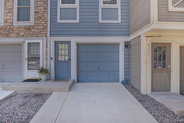 8259 S Fillmore Cir, Centennial, CO 80122 - view of exterior entry featuring stone siding, concrete driveway, and a garage
