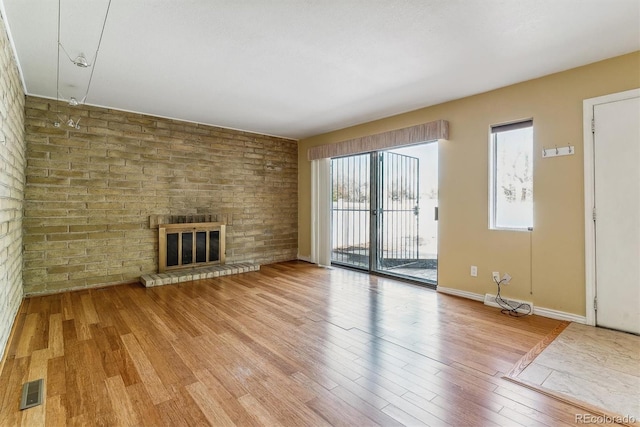unfurnished living room featuring light wood-type flooring, a fireplace, and baseboards