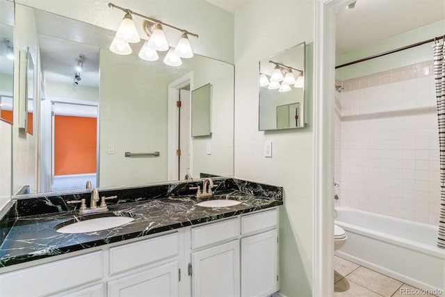 full bath with tile patterned flooring, shower / washtub combination, double vanity, and toilet