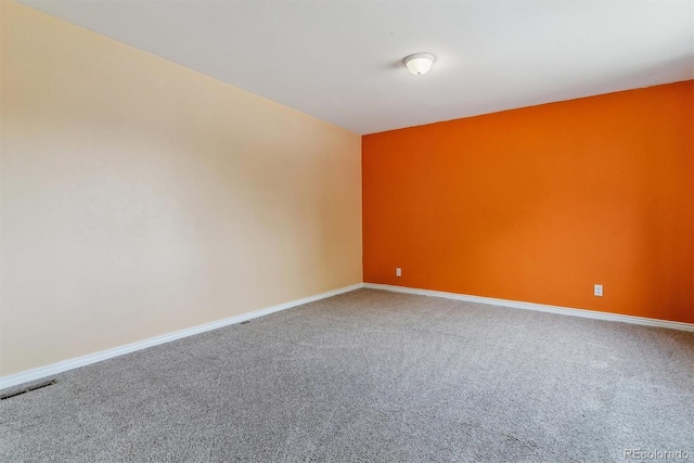 unfurnished room with carpet flooring and baseboards