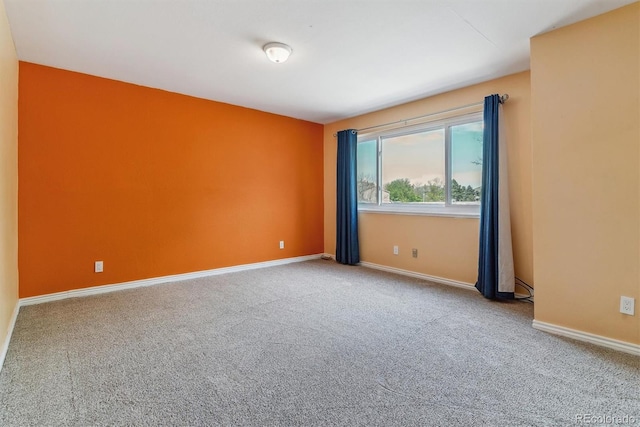 carpeted spare room featuring baseboards