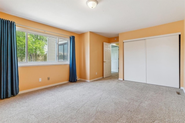 unfurnished bedroom featuring carpet, a closet, and baseboards