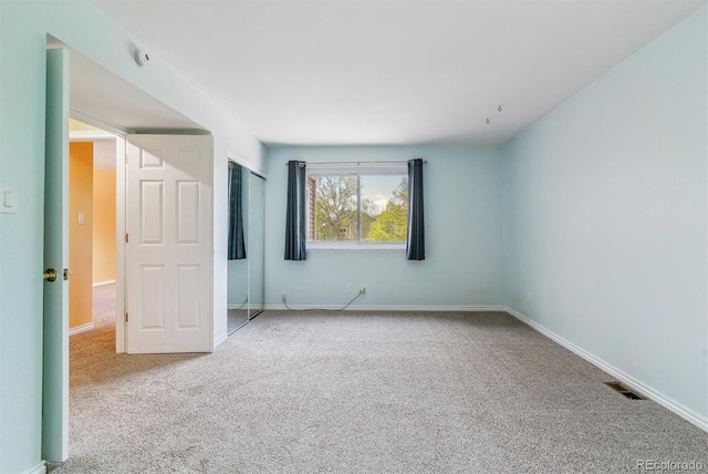 unfurnished room with carpet floors and baseboards