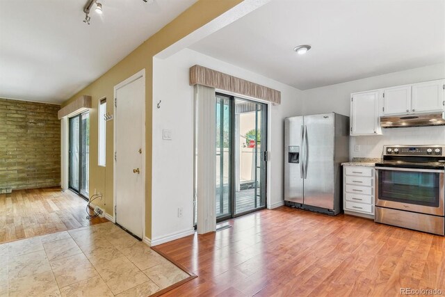 kitchen with stainless steel appliances, under cabinet range hood, light wood-style flooring, white cabinetry, and baseboards
