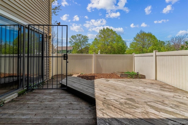 wooden deck with a fenced backyard