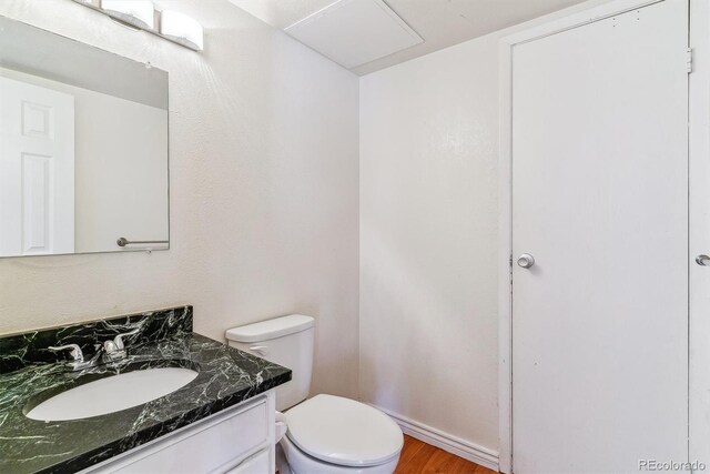 1160 S Clinton St Unit 40, Denver, CO 80247 - half bath with vanity, toilet, and wood finished floors