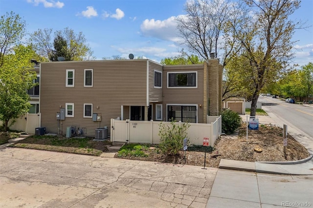 1160 S Clinton St Unit 40, Denver, CO 80247 - rear view of property featuring a chimney, a gate, and central AC unit