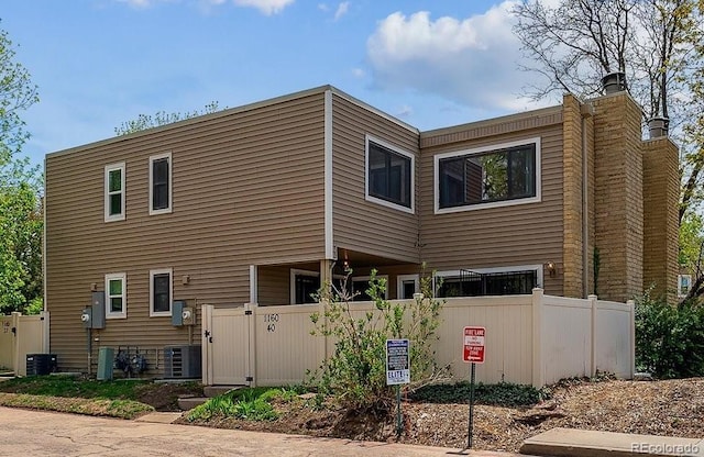 1160 S Clinton St Unit 40, Denver, CO 80247 - rear view of property featuring a chimney and central AC