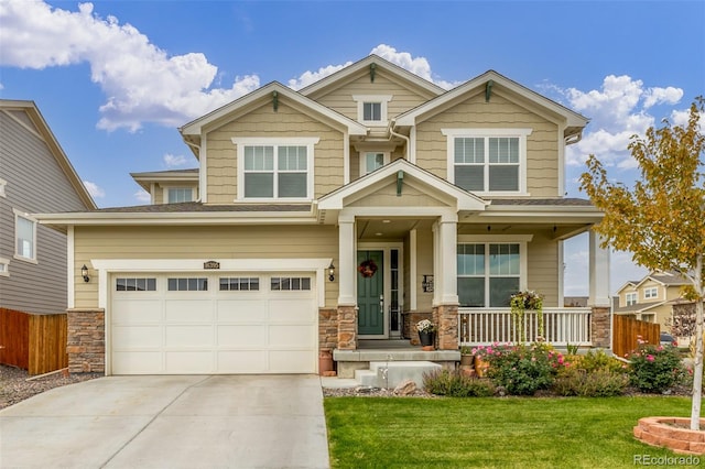 craftsman-style house featuring a porch, a front yard, and a garage