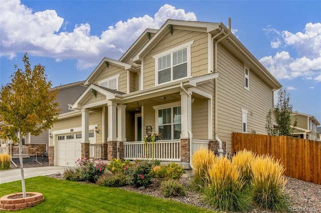 craftsman inspired home featuring covered porch, a front yard, and a garage