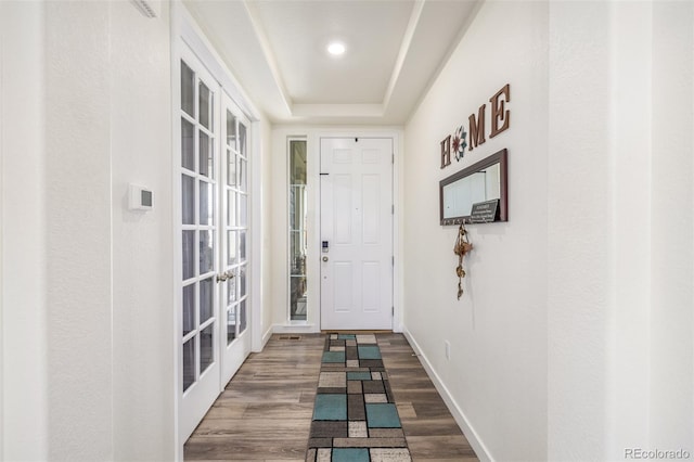 doorway to outside with hardwood / wood-style flooring and a raised ceiling