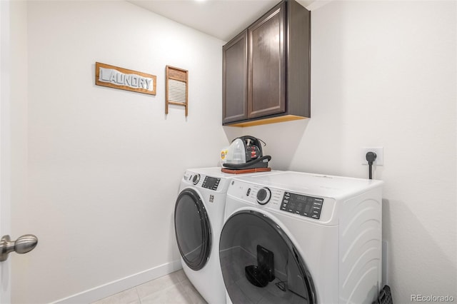 laundry area featuring cabinets, independent washer and dryer, and light tile patterned flooring