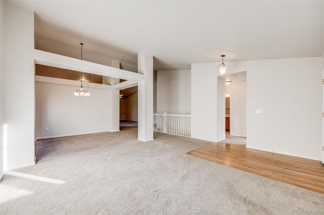 unfurnished living room featuring carpet floors and a notable chandelier