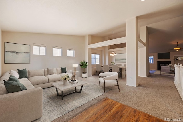 carpeted living room with an inviting chandelier and high vaulted ceiling