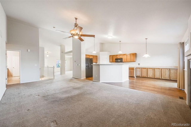 unfurnished living room with ceiling fan, light carpet, and high vaulted ceiling