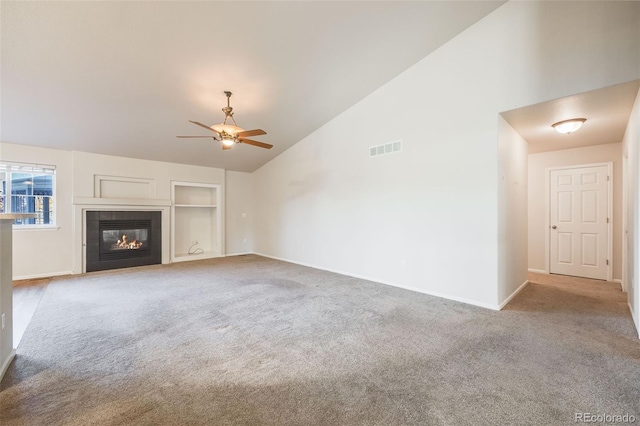 unfurnished living room featuring ceiling fan, built in features, a fireplace, and light carpet