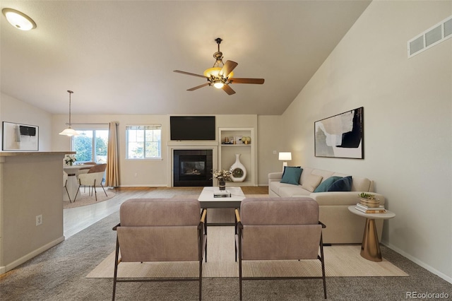 living room featuring ceiling fan, lofted ceiling, and built in features