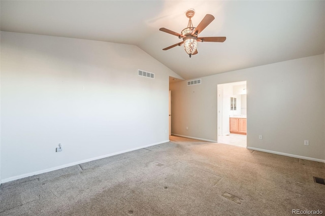 empty room featuring lofted ceiling, light colored carpet, and ceiling fan