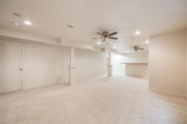 basement featuring light colored carpet and ceiling fan