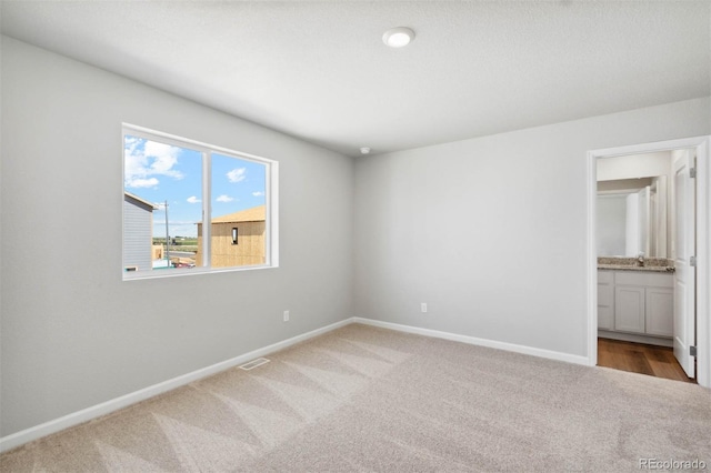 7303 Dolores Ave, Frederick, CO 80530 - unfurnished bedroom with carpet floors, baseboards, ensuite bathroom, and a sink
