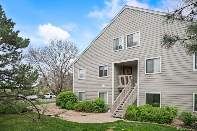 3600 S Pierce St Unit 1-207, Denver, CO 80235 - rear view of property with stairway and a lawn