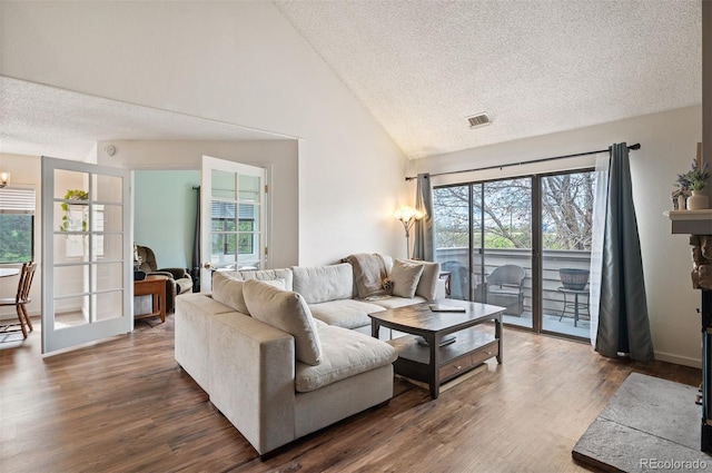 3600 S Pierce St Unit 1-207, Denver, CO 80235 - living room with a textured ceiling, plenty of natural light, dark wood-type flooring, and high vaulted ceiling