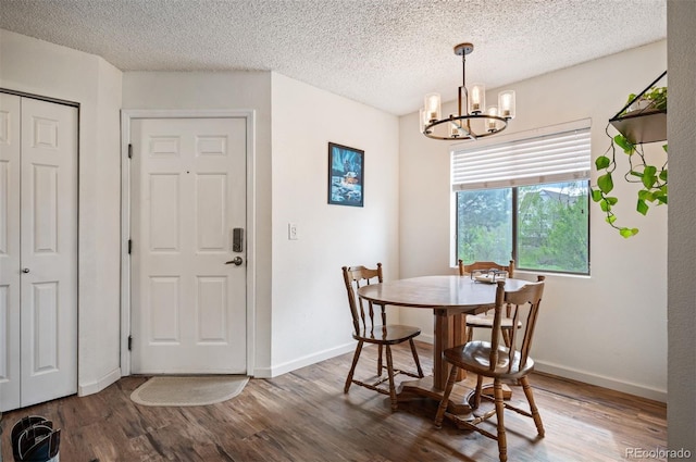 3600 S Pierce St Unit 1-207, Denver, CO 80235 - dining space with a chandelier, wood finished floors, baseboards, and a textured ceiling