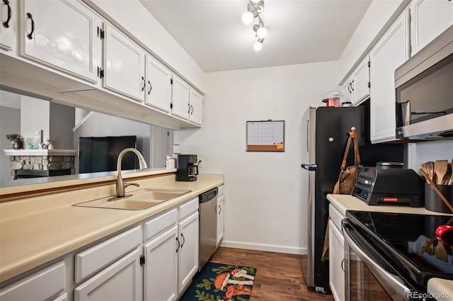 3600 S Pierce St Unit 1-207, Denver, CO 80235 - kitchen with stainless steel appliances, a sink, dark wood-style floors, light countertops, and white cabinets