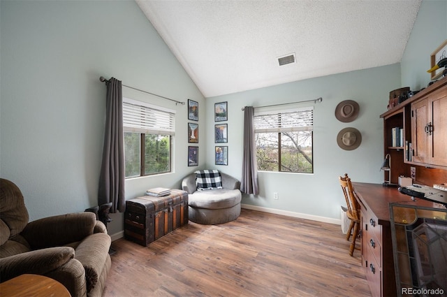 3600 S Pierce St Unit 1-207, Denver, CO 80235 - living area with wood finished floors, healthy amount of natural light, baseboards, and vaulted ceiling