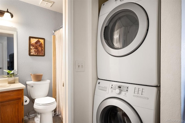 3600 S Pierce St Unit 1-207, Denver, CO 80235 - laundry room featuring stacked washer / dryer