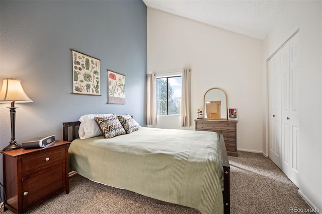 3600 S Pierce St Unit 1-207, Denver, CO 80235 - carpeted bedroom featuring high vaulted ceiling, a closet, and baseboards