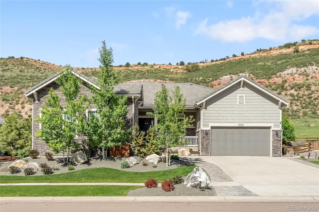 4868 Hogback Ridge Rd, Morrison, CO 80465 - view of front of home featuring concrete driveway, stone siding, and a garage