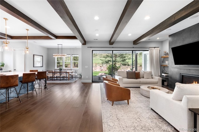 4868 Hogback Ridge Rd, Morrison, CO 80465 - living area featuring a fireplace, wood finished floors, healthy amount of natural light, beam ceiling, and baseboards