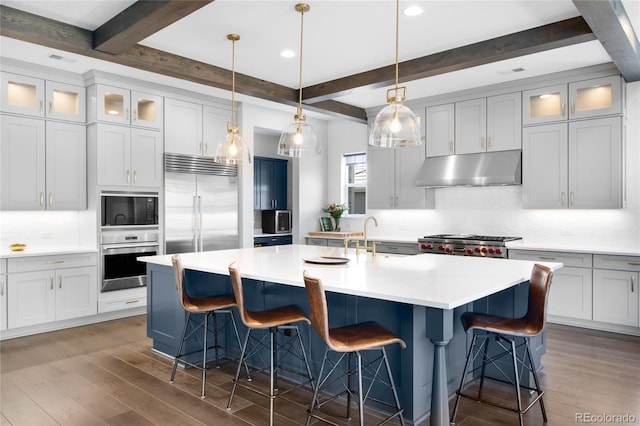 4868 Hogback Ridge Rd, Morrison, CO 80465 - kitchen with built in appliances, under cabinet range hood, beamed ceiling, dark wood finished floors, and backsplash