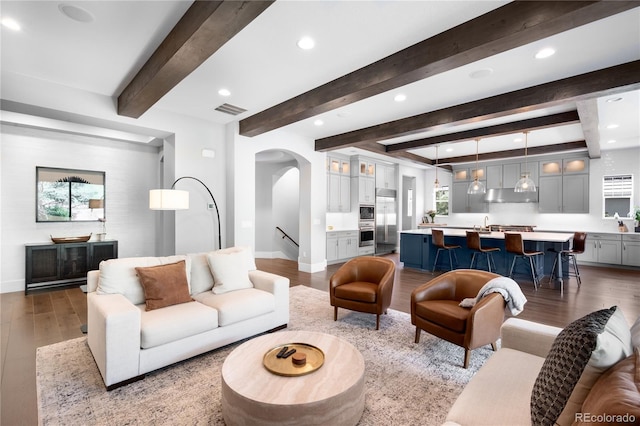 4868 Hogback Ridge Rd, Morrison, CO 80465 - living room with wood finished floors, arched walkways, recessed lighting, baseboards, and beam ceiling