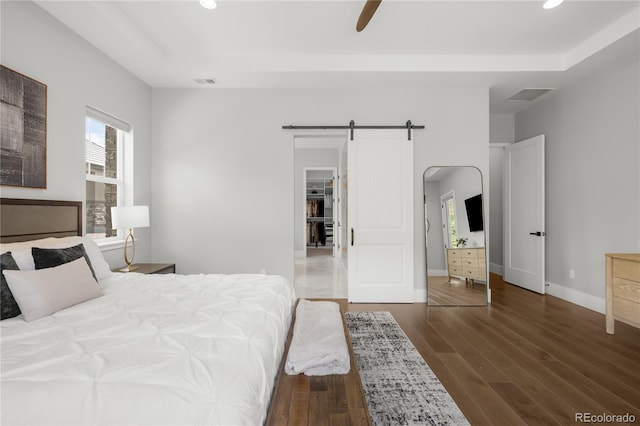 4868 Hogback Ridge Rd, Morrison, CO 80465 - bedroom featuring a barn door, dark wood-style flooring, recessed lighting, baseboards, and a raised ceiling