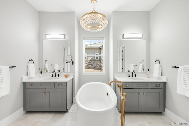 4868 Hogback Ridge Rd, Morrison, CO 80465 - bathroom with baseboards, a chandelier, a freestanding tub, and two vanities