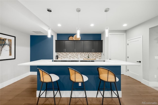 4868 Hogback Ridge Rd, Morrison, CO 80465 - kitchen featuring wood finished floors, decorative backsplash, light countertops, baseboards, and recessed lighting