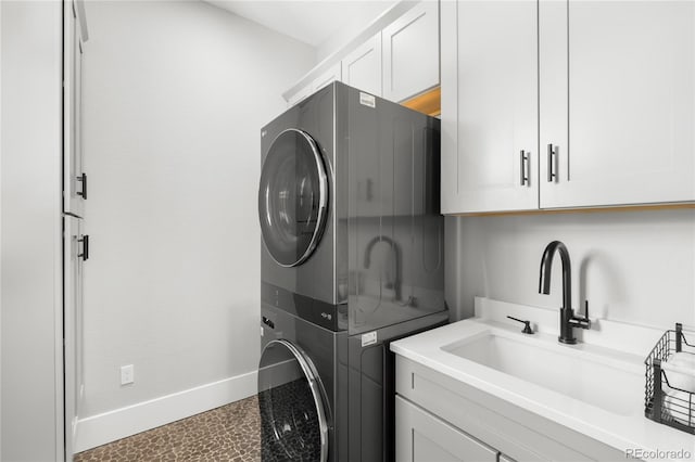 4868 Hogback Ridge Rd, Morrison, CO 80465 - washroom with stacked washer / drying machine, cabinet space, and baseboards