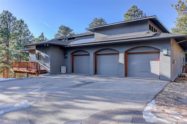 view of property exterior featuring a garage and a wooden deck